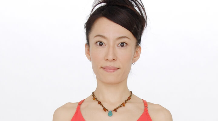Fumiko Takatsu looking straight at the camera with wide opened eyes showing an exercise for frown lines.