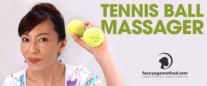 Fumiko Takatsu holding twi tennis balls in her lifted left hand.