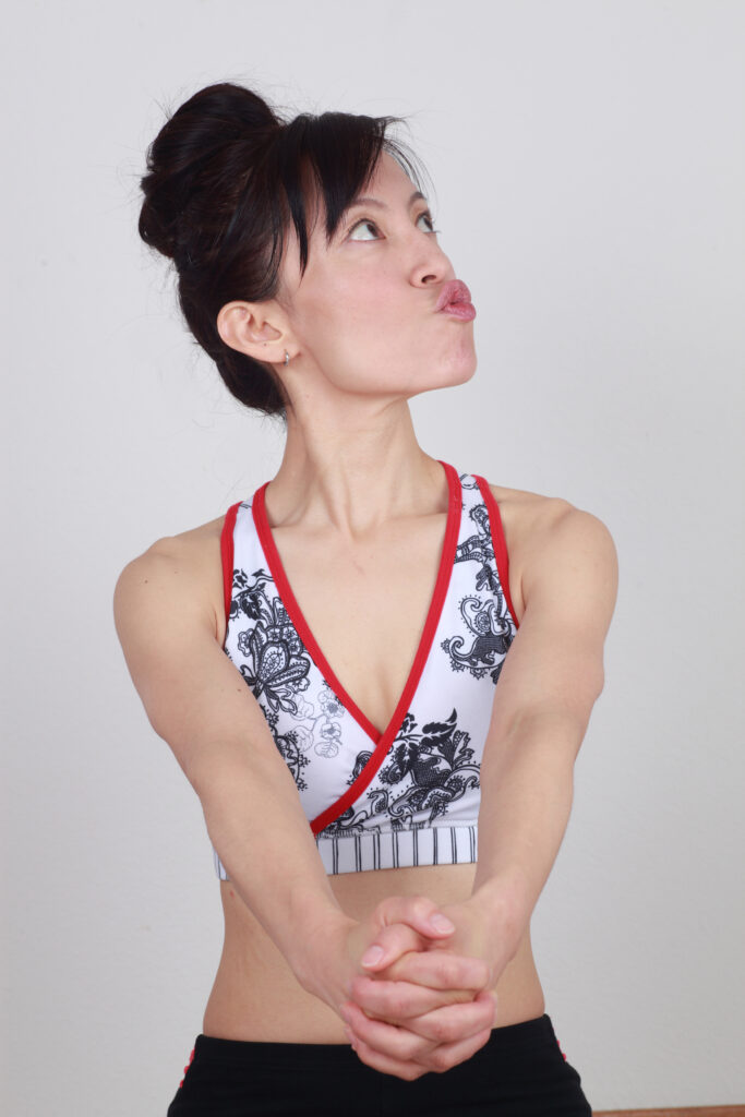 Fumiko Takatsu doing a Face Yoga exercise for reducing neck fat - Swan Neck exercise.